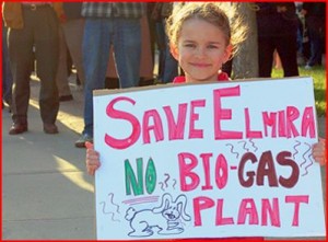 Girl holding sign: Save Elmira, No Bio-Gas Plant